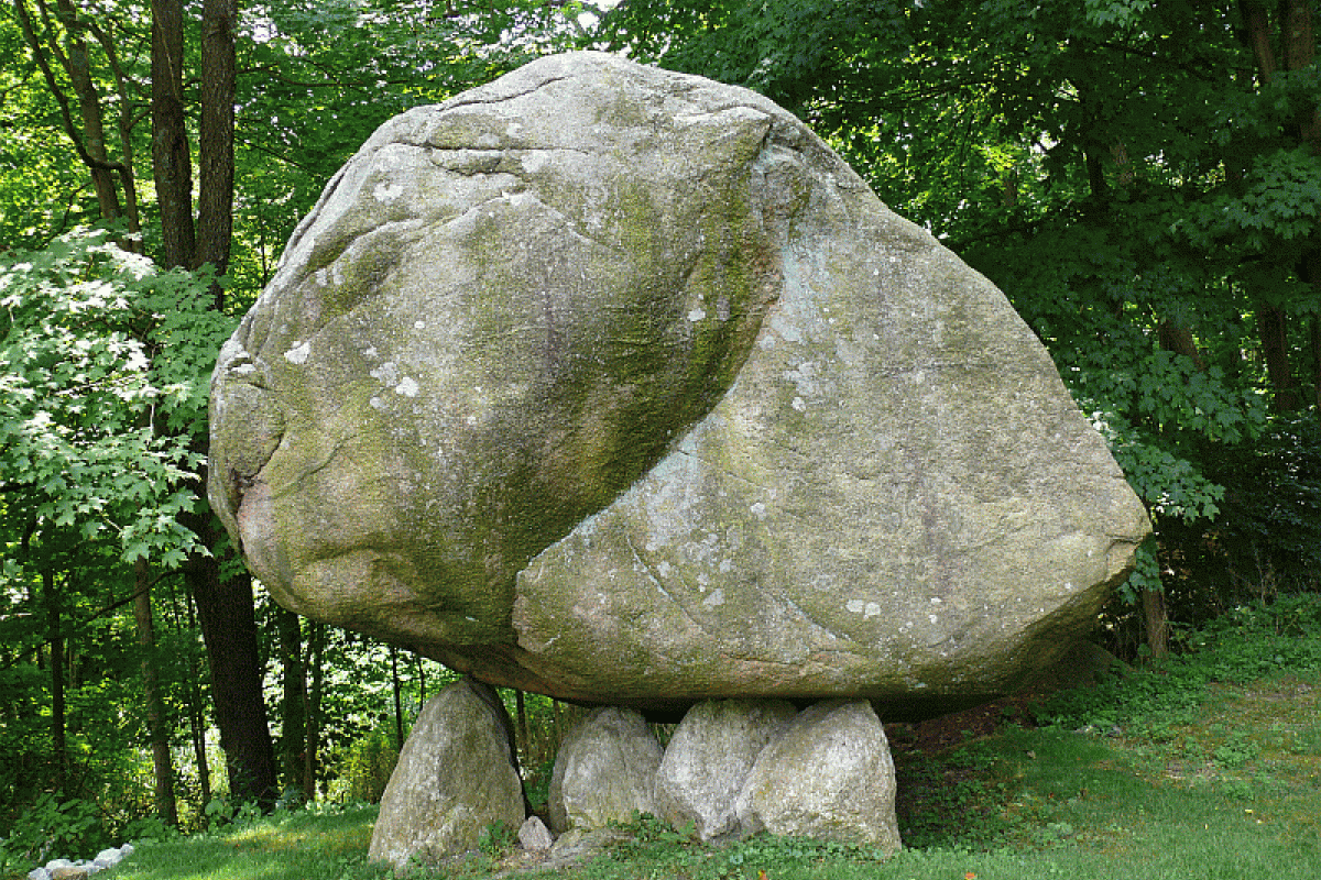 large rock balancing on several smaller rocks
